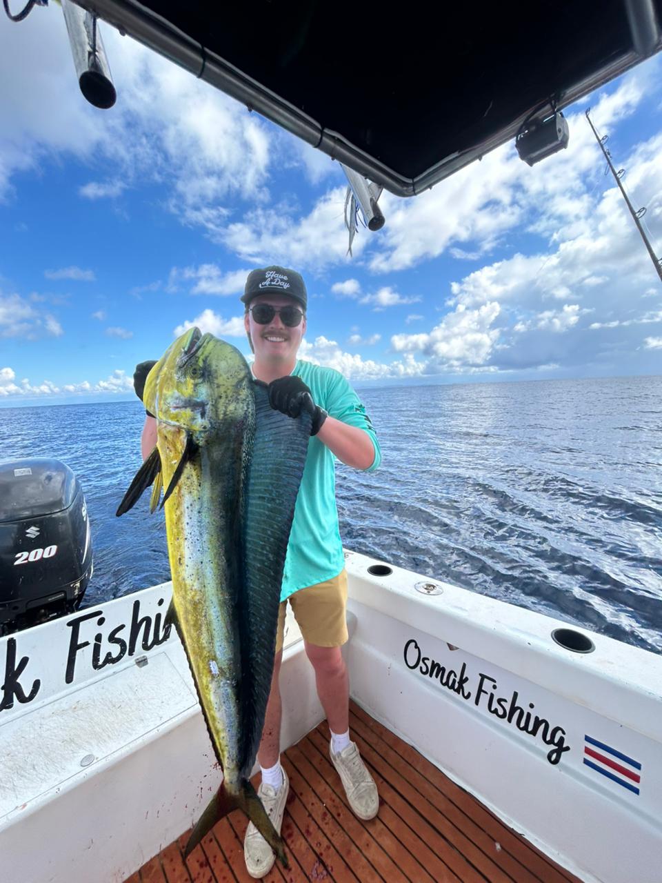 Happy angler with a huge dorado catch on Osmak Fishing